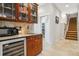 Attractive wet bar with built-in cabinets and adjacent stairway at 25015 E Park Crescent Dr, Aurora, CO 80016