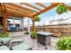Spacious backyard with a covered patio, outdoor furniture, and lush greenery at 21492 E 60Th Ave, Aurora, CO 80111