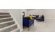 Carpeted basement featuring a comfortable blue sectional sofa and staircase at 21492 E 60Th Ave, Aurora, CO 80111