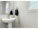 Powder room featuring pedestal sink, round mirror, and a hand towel at 21492 E 60Th Ave, Aurora, CO 80111