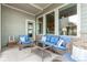 Cozy covered patio featuring comfortable blue wicker furniture and brick accents at 21492 E 60Th Ave, Aurora, CO 80111
