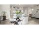 Elegant dining area with a glass table, seating for four, blending seamlessly with an open kitchen and living space at 21492 E 60Th Ave, Aurora, CO 80111