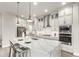 Bright kitchen features an island with bar seating, stainless steel appliances, and stylish white cabinets at 21492 E 60Th Ave, Aurora, CO 80111