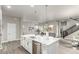 Open-concept kitchen with island, stainless steel appliances, and adjacent living area at 21492 E 60Th Ave, Aurora, CO 80111