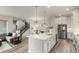 Open-concept kitchen with island, stainless steel appliances, and adjacent living area at 21492 E 60Th Ave, Aurora, CO 80111