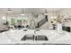 Open-concept kitchen with island, stainless steel appliances, and adjacent living area at 21492 E 60Th Ave, Aurora, CO 80111