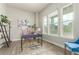 Sunlit home office features three large windows, a desk, and a comfortable chair at 21492 E 60Th Ave, Aurora, CO 80111
