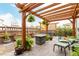 Beautiful outdoor patio with wooden pergola, fire table and green outdoor furniture at 21492 E 60Th Ave, Aurora, CO 80111