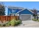 Blue two-story home with a gray attached garage, solar panels, and wood fence at 5514 Uinta St, Denver, CO 80238