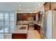 Well-lit kitchen featuring stainless steel appliances and gorgeous dark wood cabinetry at 5514 Uinta St, Denver, CO 80238