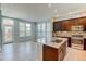 Open-concept kitchen with an island, modern appliances, hardwood floors, and bright natural light at 5514 Uinta St, Denver, CO 80238