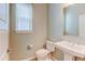 A half bathroom featuring a pedestal sink, toilet, and window at 5514 Uinta St, Denver, CO 80238