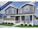 Charming two-story home with gray siding, white trim, covered porch, and attractive landscaping at 22363 E 38Th Pl, Aurora, CO 80019
