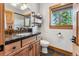 Bathroom featuring a wooden vanity, stone countertop, and a window with wooded outdoor view at 384 Camron Ln, Breckenridge, CO 80424