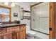 Bathroom featuring a wooden vanity, stone countertop, and a glass-enclosed shower with black trim at 384 Camron Ln, Breckenridge, CO 80424