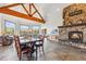 Spacious great room with a stone fireplace, wooden beams, tile floors and mountain views from the large windows at 384 Camron Ln, Breckenridge, CO 80424