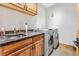 Bright laundry room features natural wood cabinets, granite countertop, washer, and dryer at 384 Camron Ln, Breckenridge, CO 80424