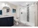 Modern bathroom with a sleek vanity, round mirror, and glass-enclosed shower with decorative tile accents at 10681 Sundial Rim Rd, Highlands Ranch, CO 80126