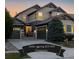 Charming two-story home boasts dual garages and attractive curb appeal in a tranquil neighborhood at dusk at 10681 Sundial Rim Rd, Highlands Ranch, CO 80126