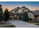 Charming two-story home featuring a well-manicured lawn, beautiful trees, and a three-car garage, all beneath a vibrant twilight sky at 10681 Sundial Rim Rd, Highlands Ranch, CO 80126