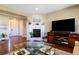 Inviting living room showcasing a cozy fireplace, a large television, and hardwood floors at 10681 Sundial Rim Rd, Highlands Ranch, CO 80126