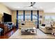 Spacious living room with hardwood floors, large windows with blue curtains, and comfortable seating at 10681 Sundial Rim Rd, Highlands Ranch, CO 80126