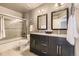 Updated bathroom with a double vanity, granite counters, and tiled tub and shower at 17059 Motsenbocker Way, Parker, CO 80134