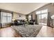 Spacious living room with high ceilings, hardwood floors, and a sliding glass door to the balcony at 17059 Motsenbocker Way, Parker, CO 80134