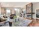 Open living room showcasing a stone fireplace, hardwood floors, and balcony access at 17059 Motsenbocker Way, Parker, CO 80134