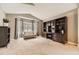 Spacious living room featuring large windows, built-in shelving, and neutral carpeting at 17059 Motsenbocker Way, Parker, CO 80134