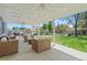 Covered back patio with a seating area, ceiling fans, and a well-maintained lawn and landscaping at 6975 S Wadsworth Ct, Littleton, CO 80128