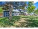Expansive backyard featuring lush lawn, mature trees, covered patio and shed for outdoor enjoyment at 6975 S Wadsworth Ct, Littleton, CO 80128