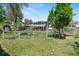 Large fenced backyard with mature trees, a shed, and a view of the home's exterior at 6975 S Wadsworth Ct, Littleton, CO 80128