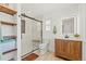 Bright bathroom featuring a sleek glass shower and a stylish wooden vanity at 6975 S Wadsworth Ct, Littleton, CO 80128