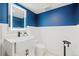 Stylish half-bathroom with blue accent wall, and elegant fixtures at 6975 S Wadsworth Ct, Littleton, CO 80128