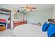 Bright bedroom with a ceiling fan, closet, hats, and a queen-sized bed with blue pillows at 6975 S Wadsworth Ct, Littleton, CO 80128