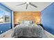 Comfortable bedroom with blue accent wall, a wooden accent wall, and natural light at 6975 S Wadsworth Ct, Littleton, CO 80128