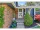 Inviting entryway with brick accents, mature plantings and glass paneled front door at 6975 S Wadsworth Ct, Littleton, CO 80128