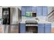 Modern kitchen boasts stainless appliances, stylish blue cabinetry and bright white countertops at 6975 S Wadsworth Ct, Littleton, CO 80128