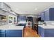 Spacious kitchen with stainless steel appliances, white countertops, blue cabinets, and convenient workspace at 6975 S Wadsworth Ct, Littleton, CO 80128