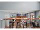 Open-concept living room features a live edge bar with seating and a cozy seating area with a brick fireplace at 6975 S Wadsworth Ct, Littleton, CO 80128