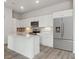 A modern kitchen featuring white cabinets, stainless steel appliances, and an island with a sink at 487 Interlocken Blvd # 409, Broomfield, CO 80021