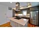 Modern kitchen boasts stainless steel appliances, center island with cooktop, and stylish wood cabinets at 3404 W 18Th Ave, Denver, CO 80204