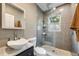 Modern bathroom features a vessel sink, gray tile, and a glass-enclosed shower at 249 S Lincoln St, Denver, CO 80209