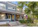 Charming painted brick duplex with a covered front porch, American flag, and landscaped front yard at 249 S Lincoln St, Denver, CO 80209