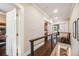 Hallway featuring hardwood floors, wood railing and doors that lead to the bedrooms at 249 S Lincoln St, Denver, CO 80209