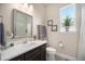 Elegant bathroom showcasing a decorative mirror, modern vanity, and a sunlit window with vibrant greenery at 11168 Sweet Cicely Dr, Parker, CO 80134