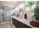 Modern bathroom featuring double sinks, sleek vanity, and a glass-enclosed shower at 11168 Sweet Cicely Dr, Parker, CO 80134