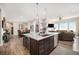 Open-concept kitchen and living space with stainless appliances, a large island, and a cozy fireplace at 11168 Sweet Cicely Dr, Parker, CO 80134