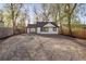 Large backyard area featuring a pergola and gravel area with surrounding trees at 1755 Ingalls St, Lakewood, CO 80214